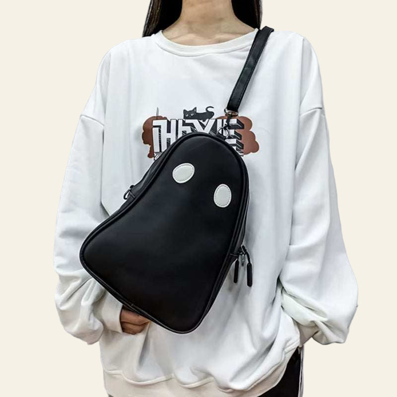 Black Halloween cartoon ghost-shaped crossbody bag with white eyes worn with white oversized sweatshirt