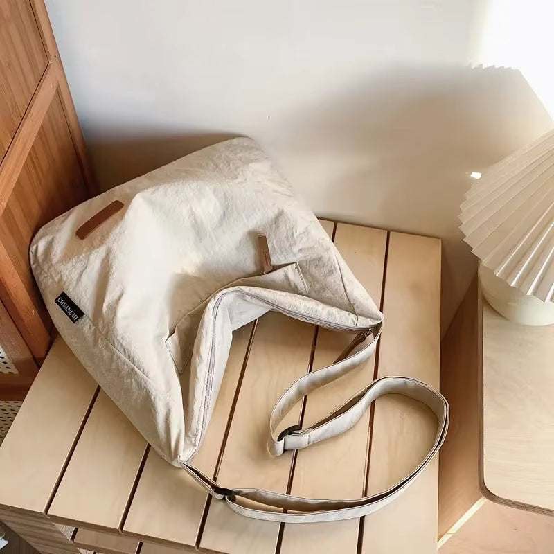 Japanese unisex shoulder bag in beige canvas on wooden table with lamp