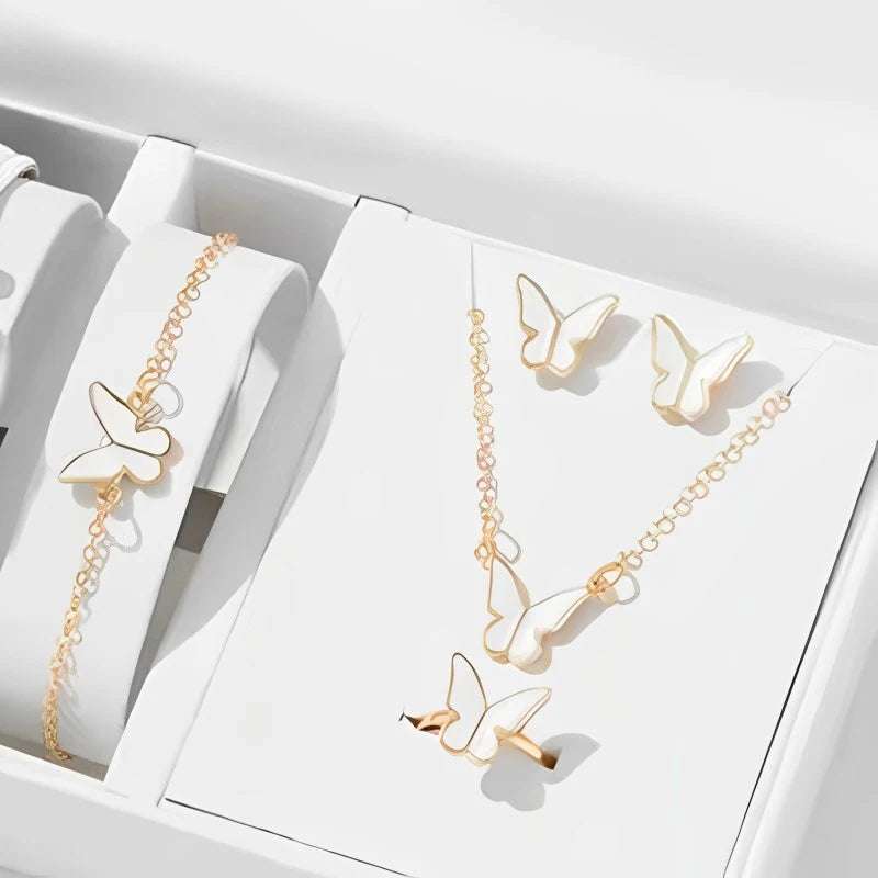 Gold butterfly pendants necklace set with matching bracelet, earrings, and ring on white display