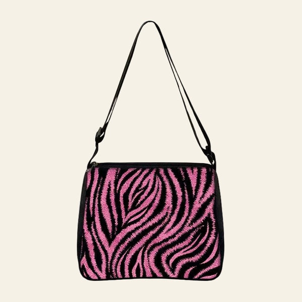 Small shoulder bag with pink and black zebra print design and adjustable strap