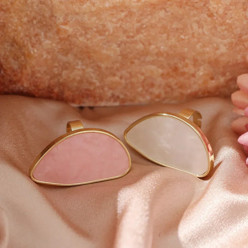 Fashion woman rings with pink and white stones and gold trim on satin background
