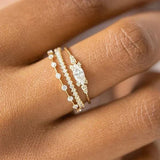 Close-up of hand wearing three delicate stackable gold rings with cubic zirconia stones