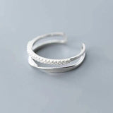 silver fidget spinner ring with a row of small sparkling stones on a gray background