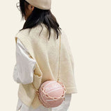 Teen girl wearing a cream knit vest and beret with a pink basketball-shaped PU leather ball purse crossbody bag with acrylic chain strap.