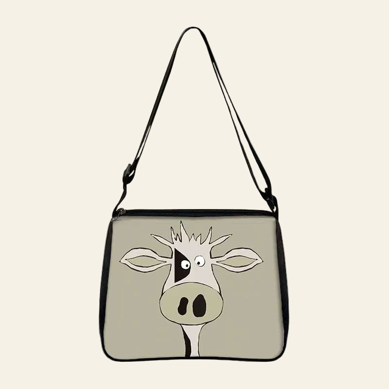 Cow print small shoulder bag with cartoon cow face design and adjustable strap